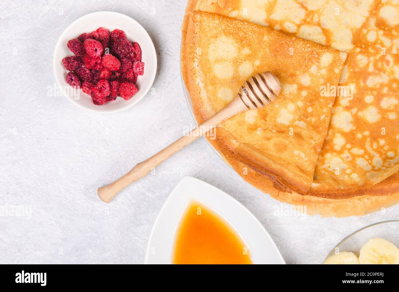 Crêpes avec baies et miel pour le petit déjeuner sur table rustique blanche Banque D'Images
