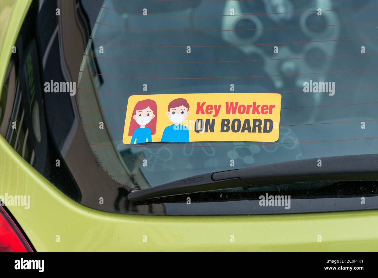 Un autocollant d'employé clé sur une fenêtre de voiture pendant la crise pandémique COVID-19 du coronavirus. Banque D'Images