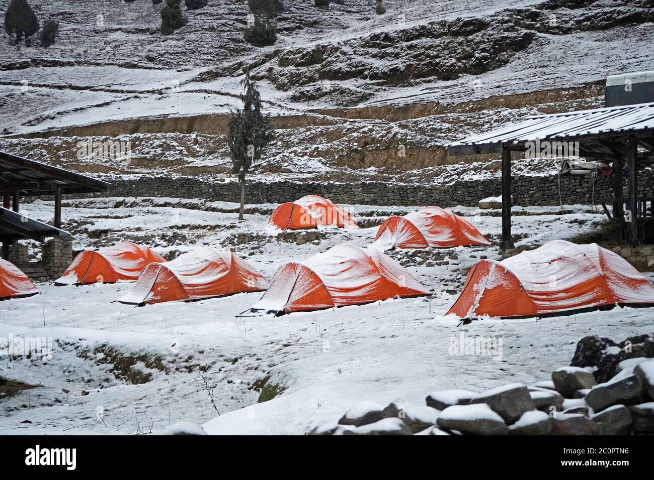 Camping en hiver, tentes orange couvertes de neige. Sakteng, Bhoutan oriental Banque D'Images