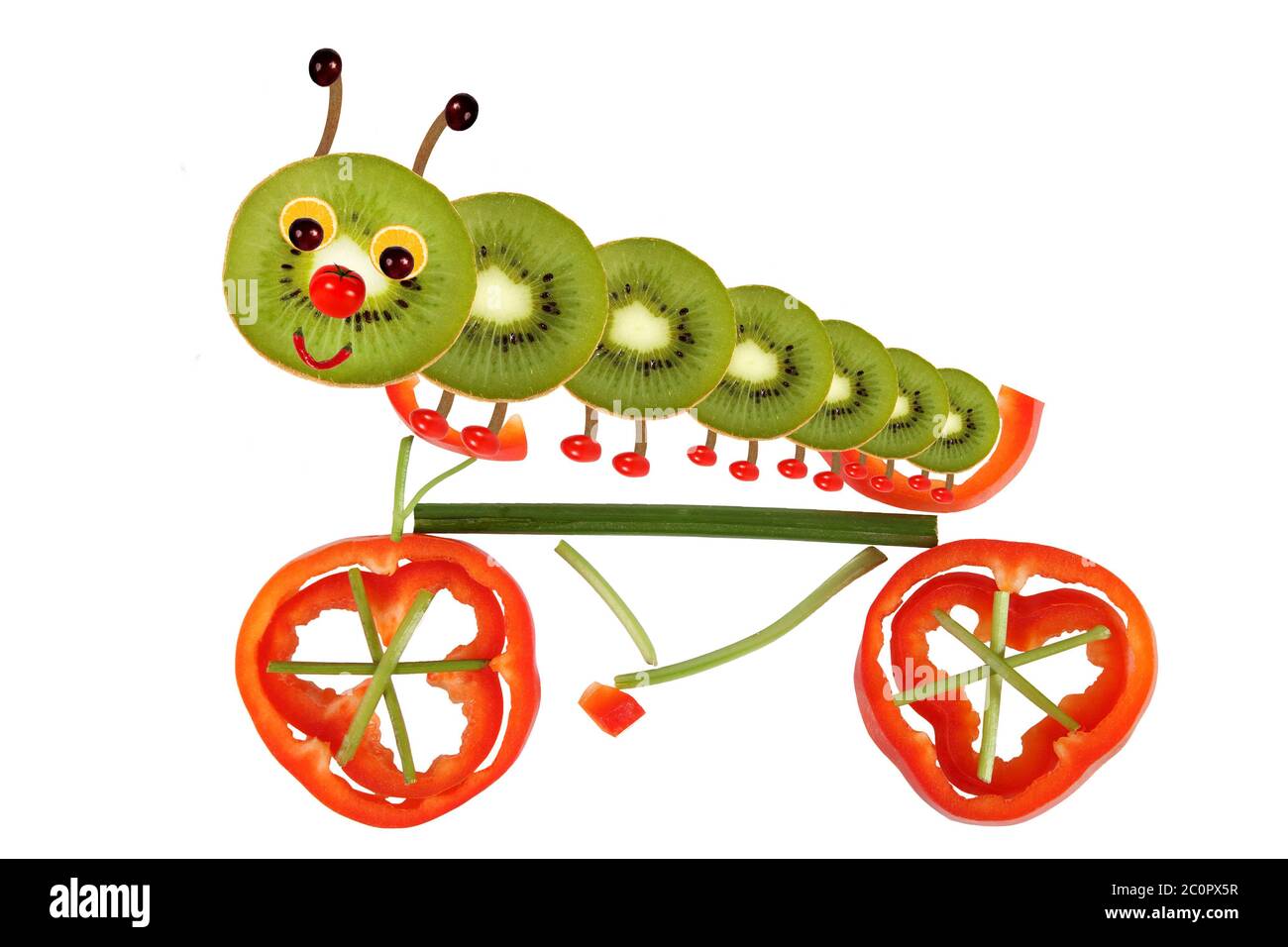 Concept de cuisine créative. Drôle de petite chenille sur une bicyclette à base de fruits et légumes Banque D'Images