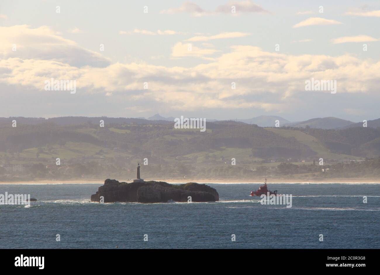 Isla del Mouro ou l'île de Moors avec le garde-côtes rouge Bateau passant sur son chemin vers la mer Santander Cantabria Espagne Banque D'Images