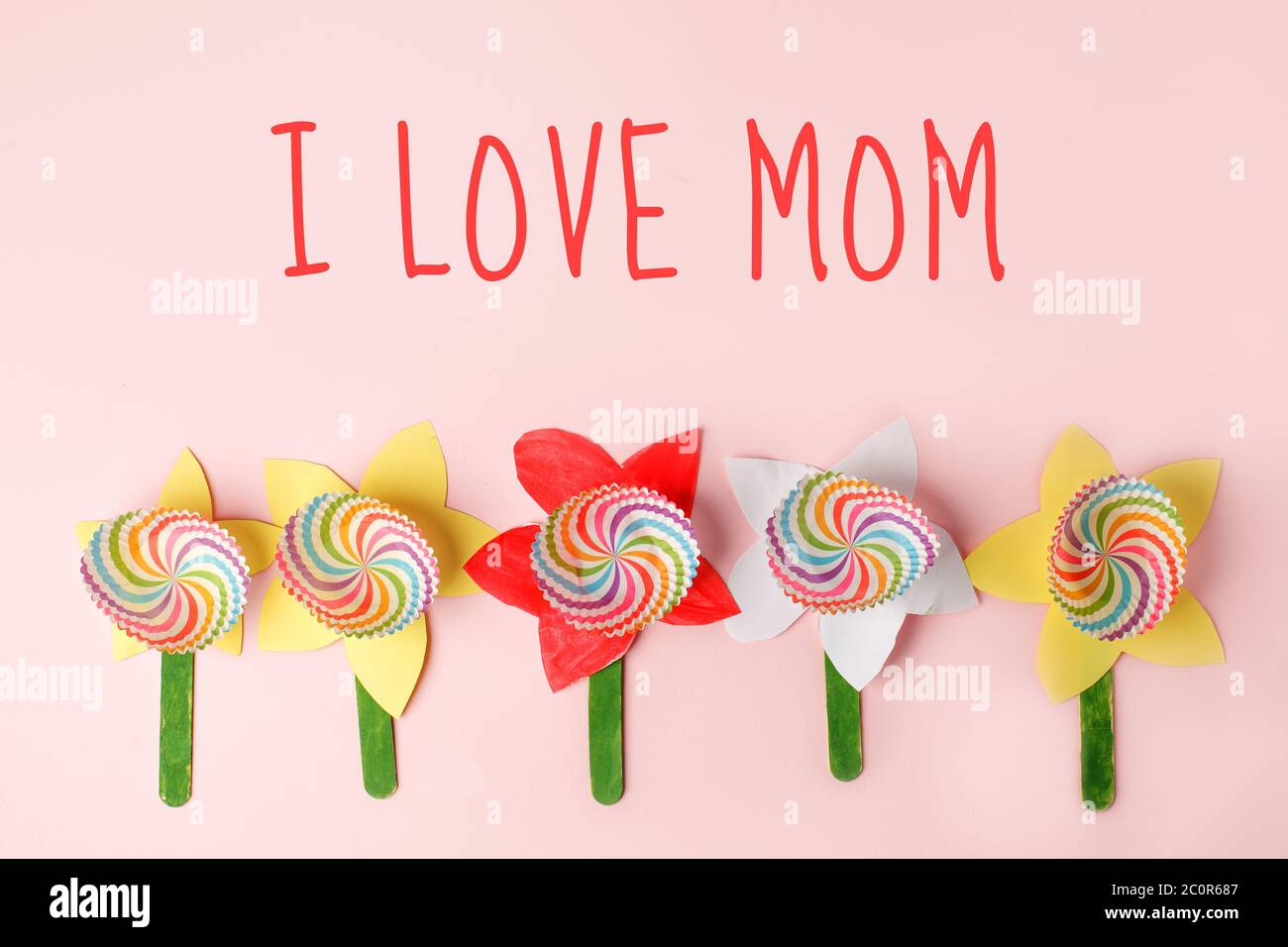 Message de la fête des mères J'AIME MOM avec des fleurs artisanales sur tableau rose pastel, idée créative, carte de vacances, garderie de garderie de bricolage concept de compétence de moteur Banque D'Images