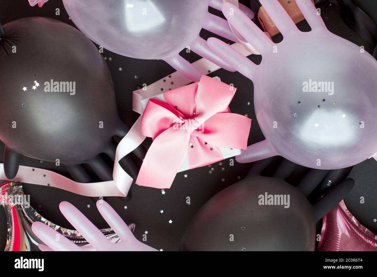 Boîte cadeau artisanale sur fond sombre, décorée avec un ballon provenant d'un gant médical et d'un noeud. Pour l'anniversaire, cadeaux d'anniversaire, cartes postales cadeaux dans la période de Banque D'Images