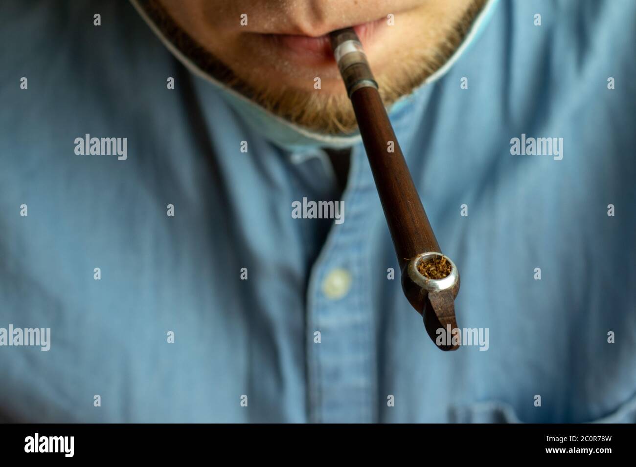 Pipe de fumer avec le tabac dans la bouche de l'homme de près. Embout buccal vintage. Banque D'Images