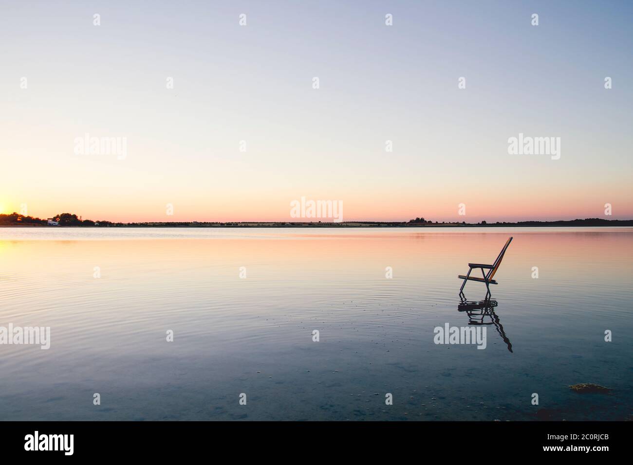 Chaise vide dans l'eau d'un lac bleu Banque D'Images