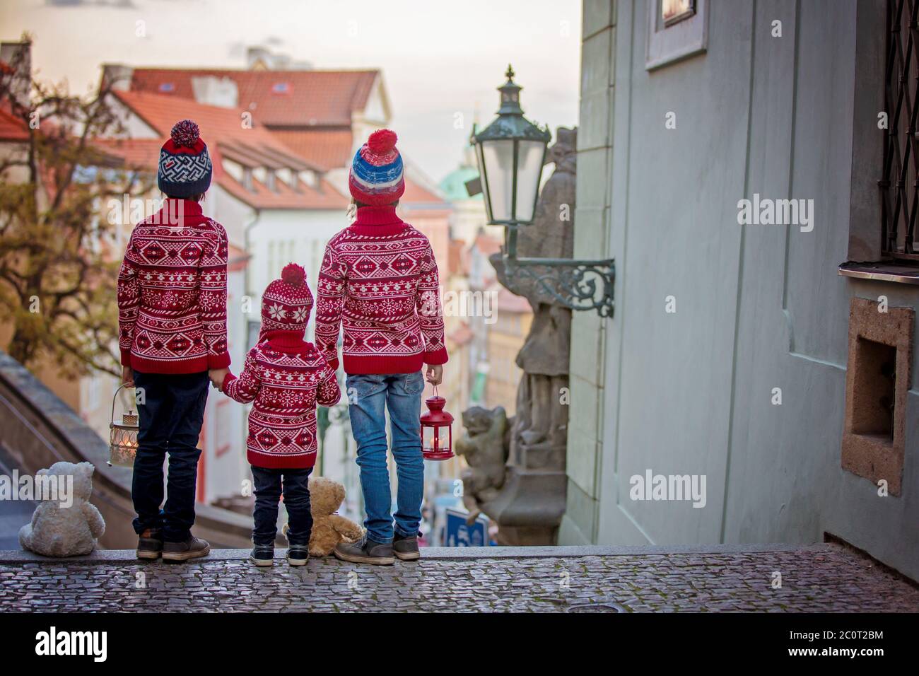 Beaux enfants, trois frères garçons, vêtus de façon décontractée, vue de nuit de Prague ville, l'hiver Banque D'Images