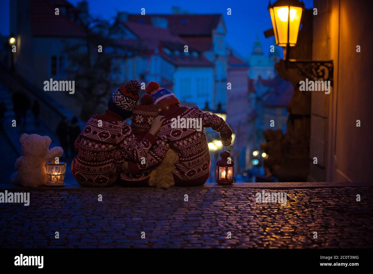 Beaux enfants, trois frères garçons, vêtus de façon décontractée, vue de nuit de Prague ville, l'hiver Banque D'Images