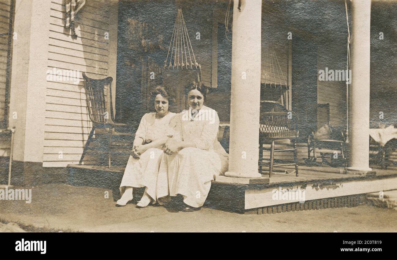 Photographie antique d'avril 1913, deux femmes assises sur le porche extérieur. Emplacement exact inconnu, probablement New Hampshire ou Massachusetts. SOURCE : PHOTO ORIGINALE Banque D'Images