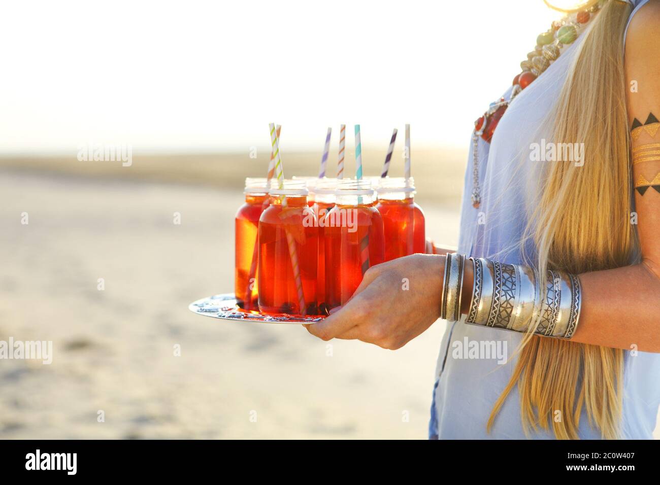 Bonne jeune femme tenant un plat avec un verre à la fête d'été Banque D'Images