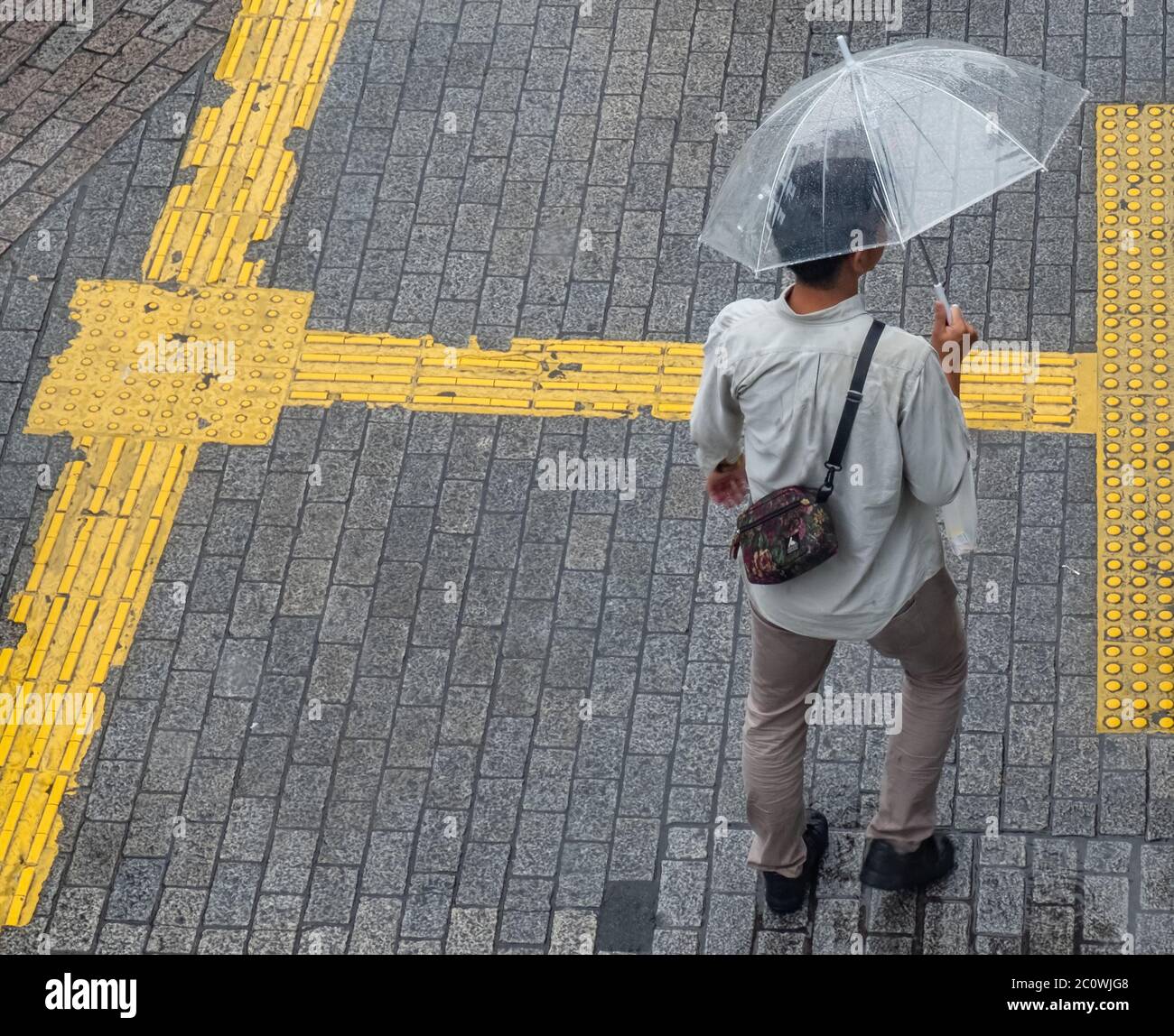 Homme avec parapluie pendant une journée de pluie à Shibuya Tokyo, Japon. Banque D'Images