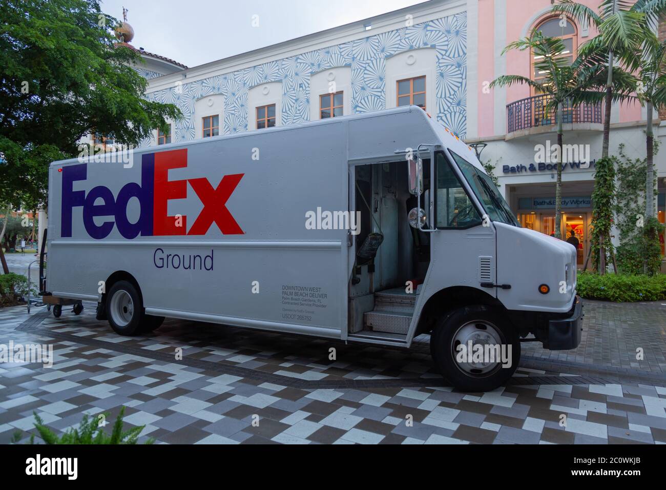 Un minibus FedEx s'arrête pour une livraison en soirée devant Bath & Body Works à Rosemary's Square à West Palm Beach, Floride, États-Unis. Banque D'Images