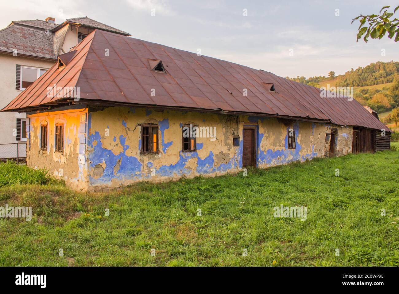 Ancienne maison de résidence abandonnée construite de Mudbricks, Red Metal Roof une architecture slovaque typique dans le passé. Banque D'Images