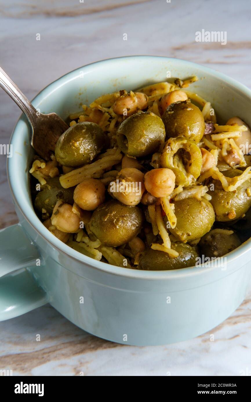 Bol de spaghetti au pesto avec des olives manzanilla, pois chiches et haricots cannellini Banque D'Images