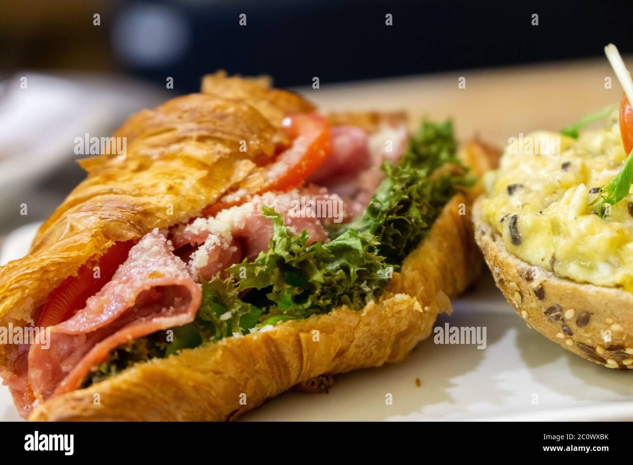 Croassant et casière avec jambon et œufs. Banque D'Images