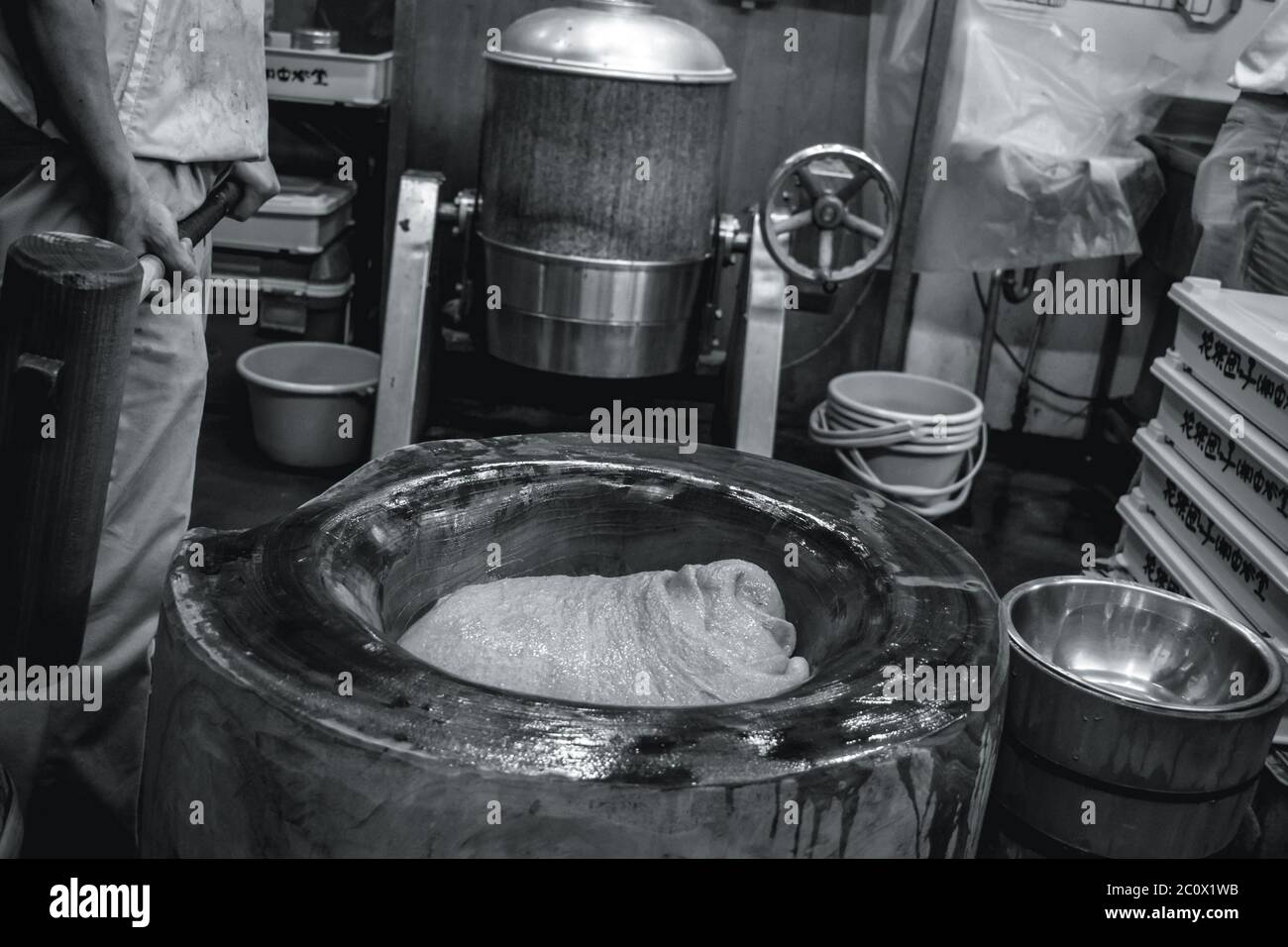 Homme avec un gros marteau préparant le mochi traditionnel japonais de riz collant Banque D'Images