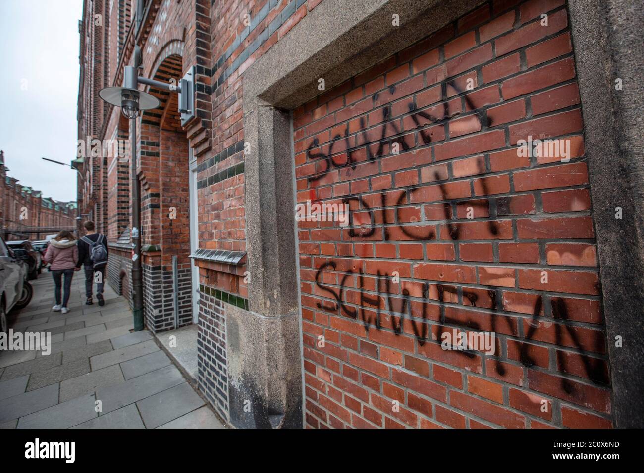 Hambourg, Allemagne. 12 juin 2020. L'image montre une mariée et un marié qui marchent à côté de l'extérieur vandalisé des bureaux de Pickhuben à Hambourg appartenant à Johann Schwenn cabinet représentant Christian Brueckner suspect dans la disparition de Madeleine McCann. 12 juin 2020. Hambourg, Allemagne, Europe Banque D'Images