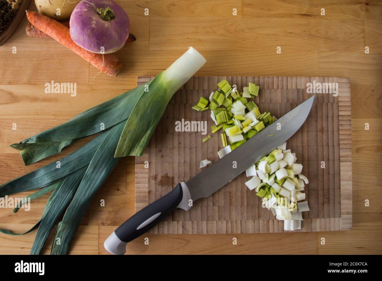 Vue de dessus d'une planche à découper, légumes d'hiver, brosse et couteau sur une table en bois Banque D'Images
