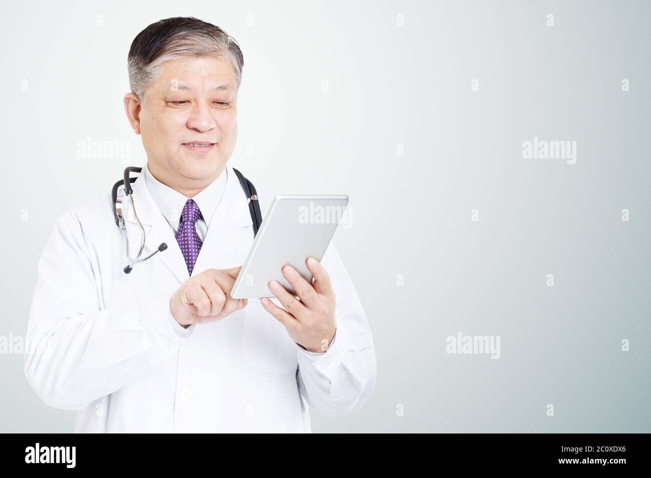 Poser des gestes et de l'ancien médecin homme asiatique Banque D'Images