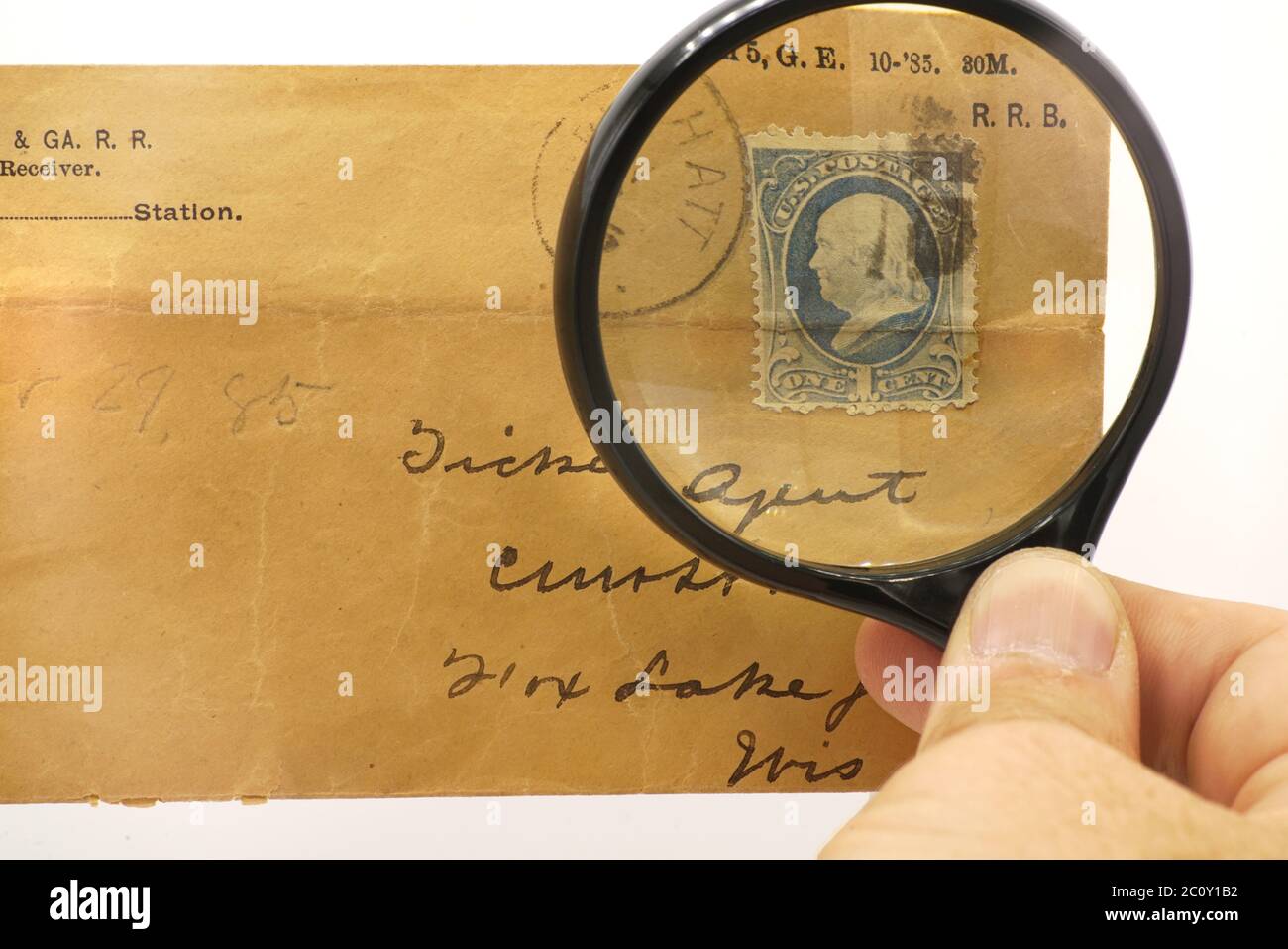 Un ancien timbre-poste en l'honneur de Benjamin Franklin sous une loupe. Banque D'Images