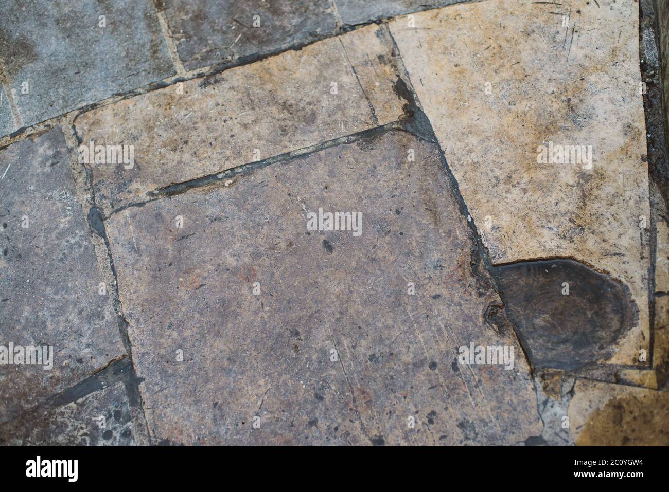 Plancher de carreaux de pierre brute avec des fissures et des petites pierres abstract background texture Banque D'Images