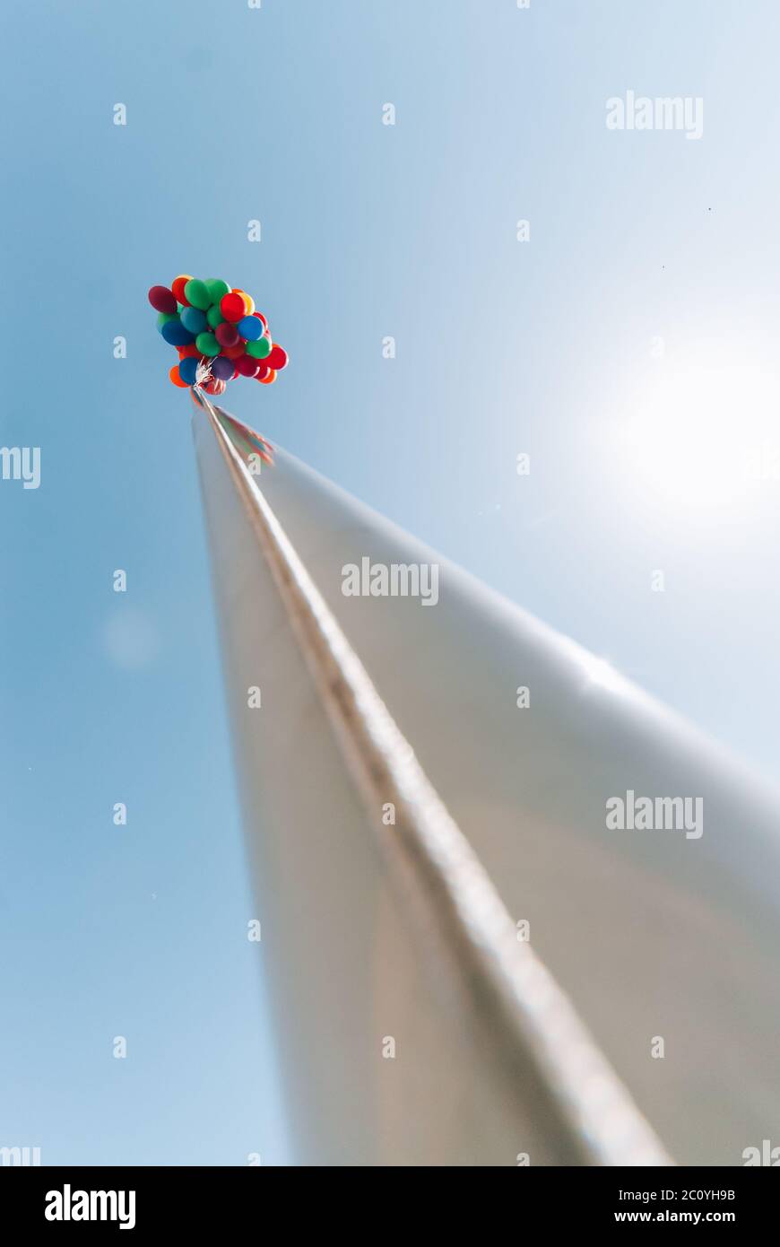 De nombreux baloons lumineux dans le ciel bleu sur le pilier. Banque D'Images
