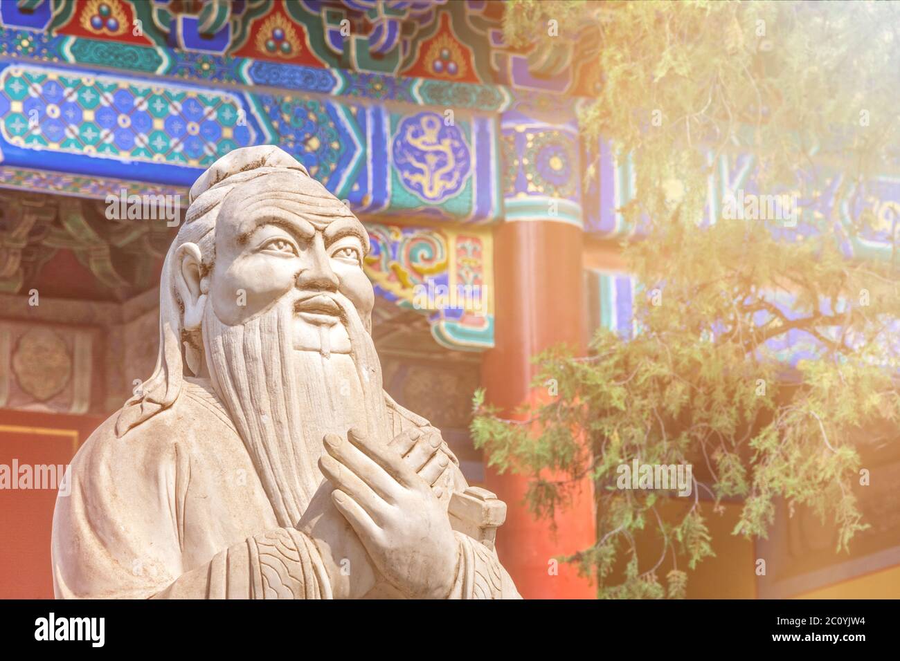 Gros plan de la statue de Confucius devant un temple ancien coloré en plein soleil Banque D'Images