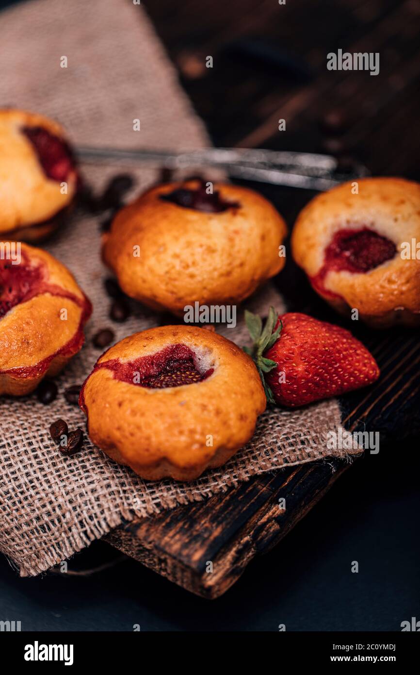 Muffins au chocolat aux fraises sur un vieux support en bois sur fond gris en béton. Banque D'Images