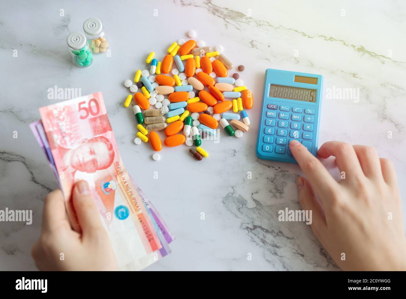 Peso philippin argent, calculatrice et médicaments pilules. Coût des soins de santé aux Philippines Banque D'Images