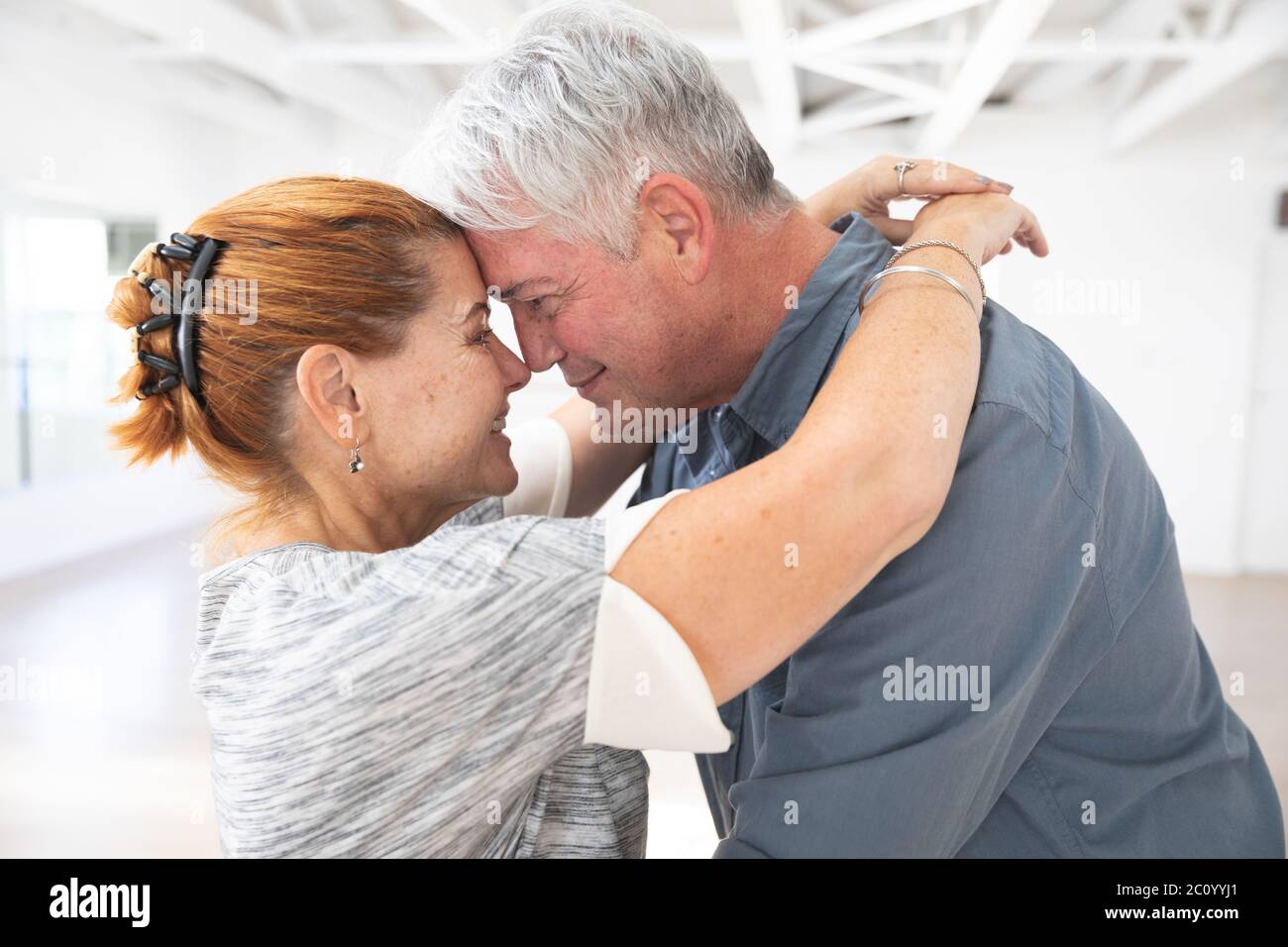 Couple de personnes âgées de race blanche heureux pendant la séance de danse de la salle de bal Banque D'Images