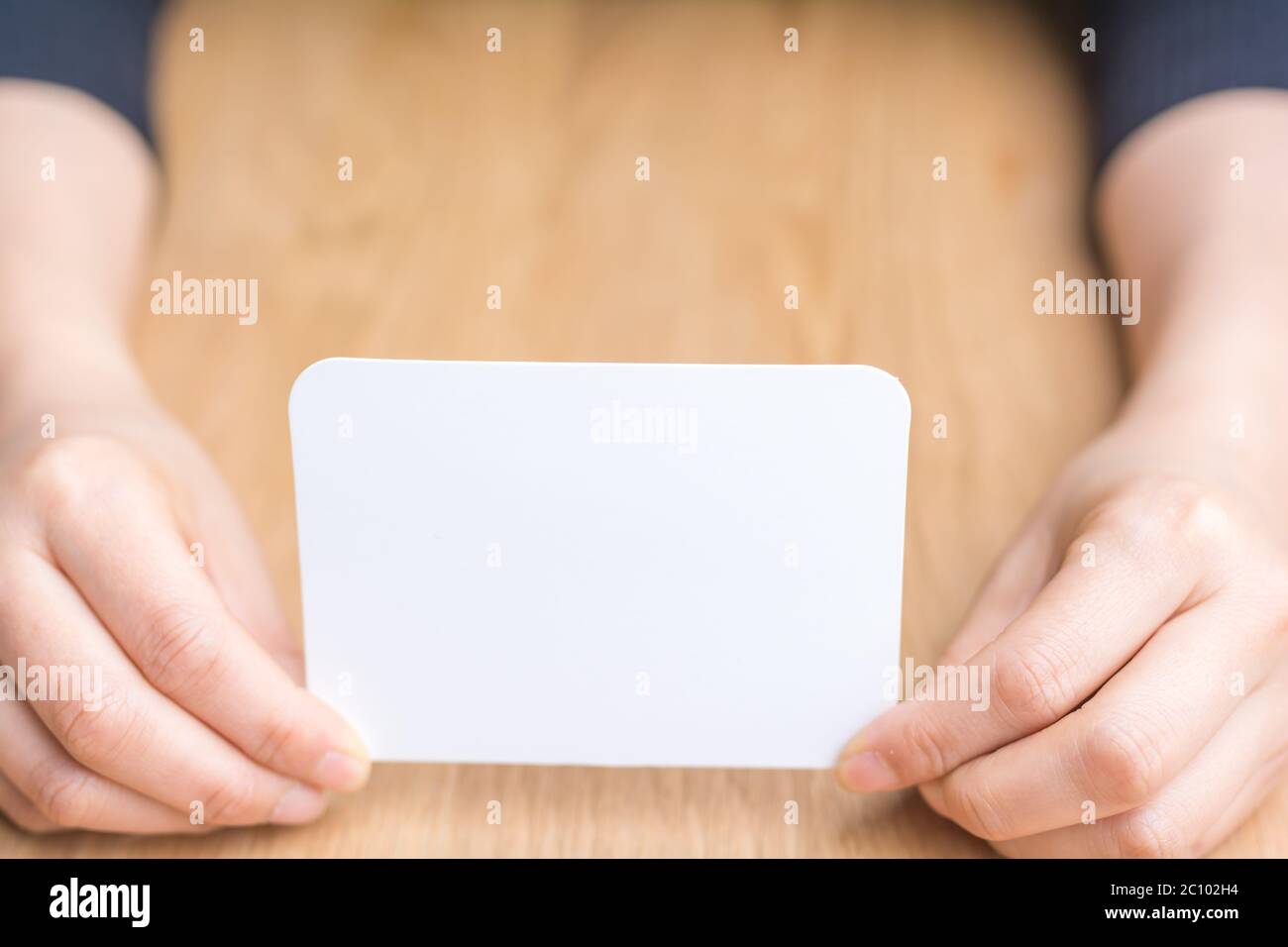 Woman's hand holding white papier vierge Banque D'Images