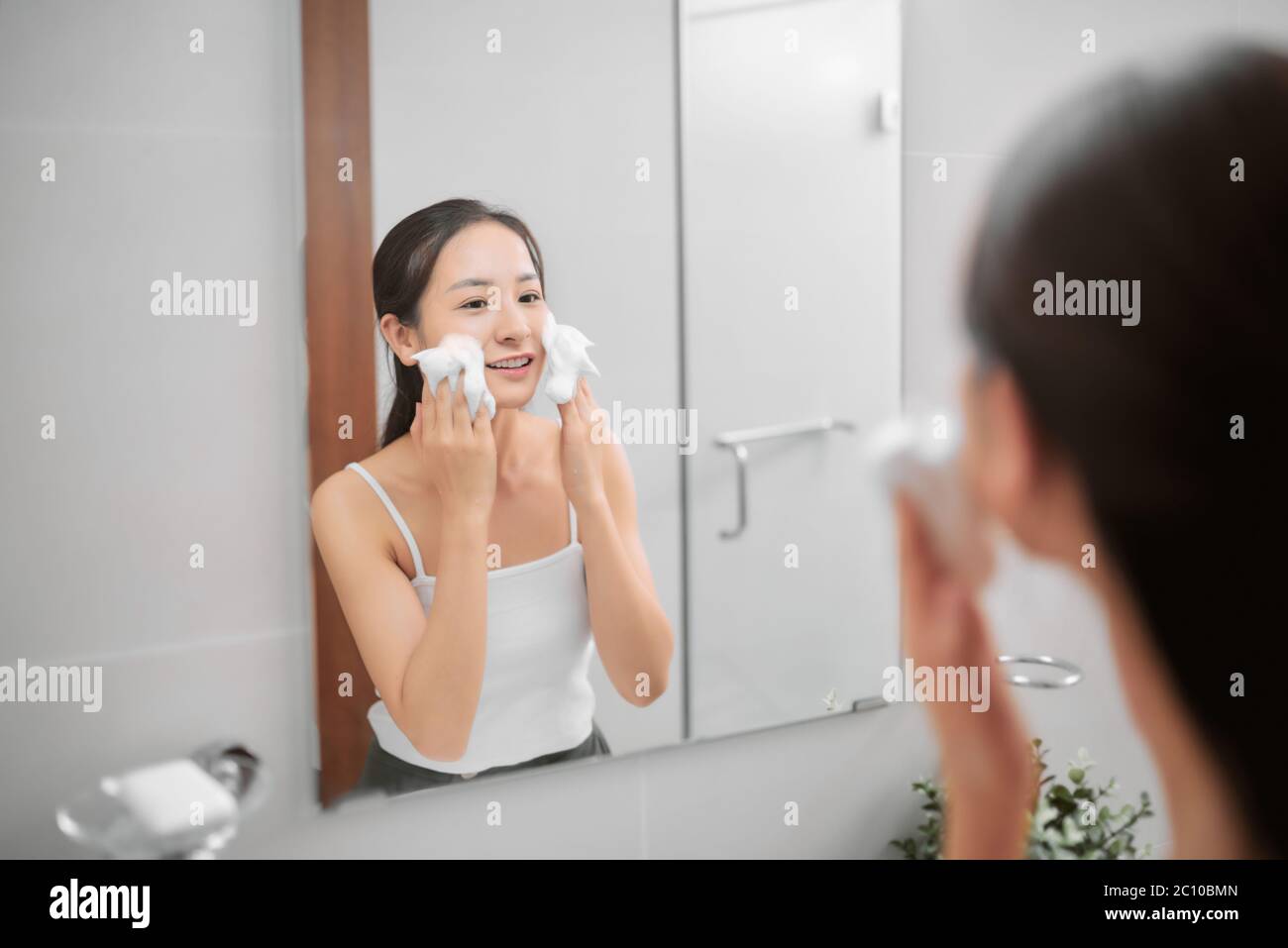 Femme asiatique adulte nettoyage visage dans l'eau chaude à la maison le matin. Profitez d'un moment de détente. Banque D'Images