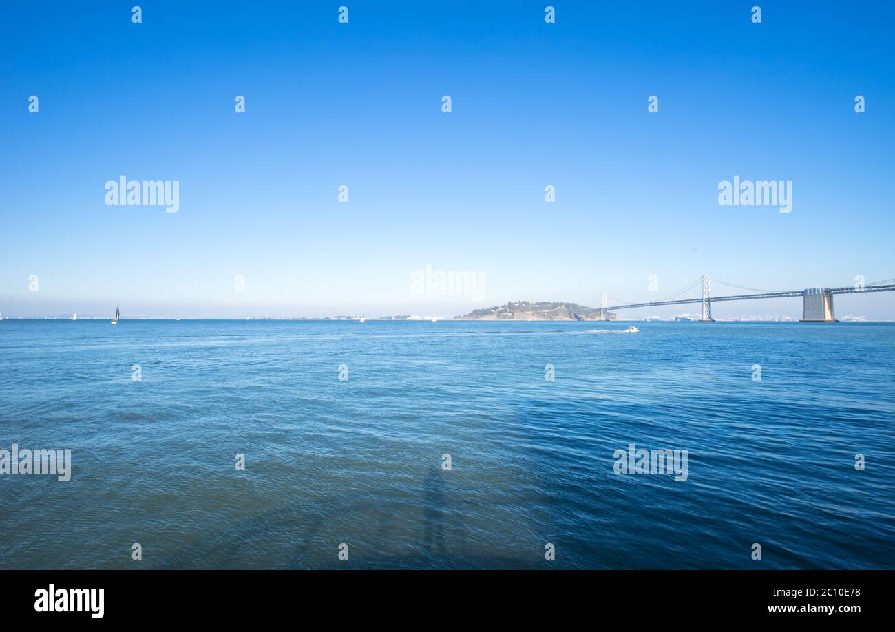 Monument Bay Bridge sur la mer tranquille dans le ciel bleu Banque D'Images
