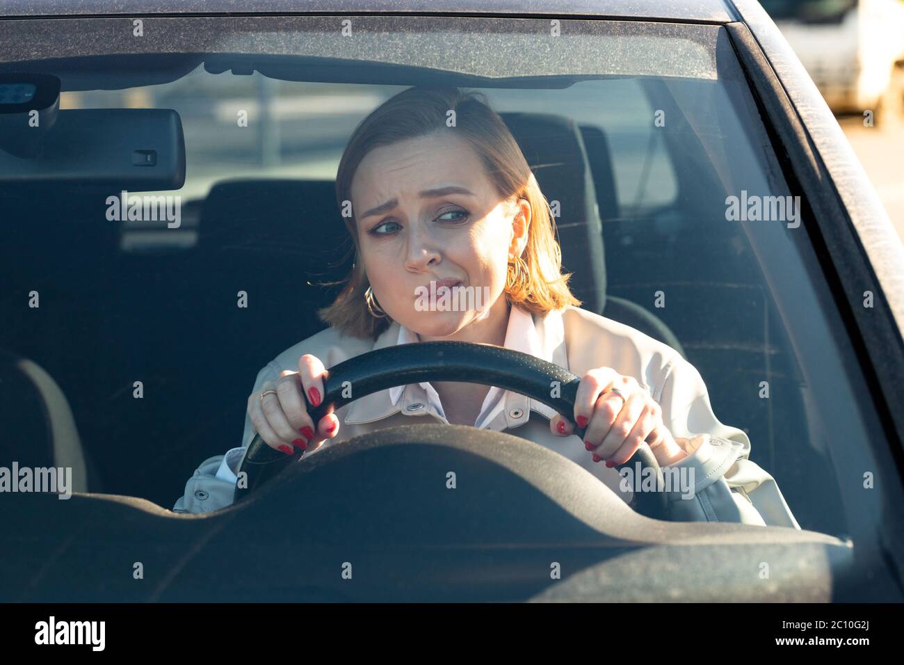 Femme conduit sa voiture pour la première fois, tente d'éviter un accident de voiture, est très nerveux et peur, s'inquiète, se crampon étroitement à la roue. Inexpérience Banque D'Images