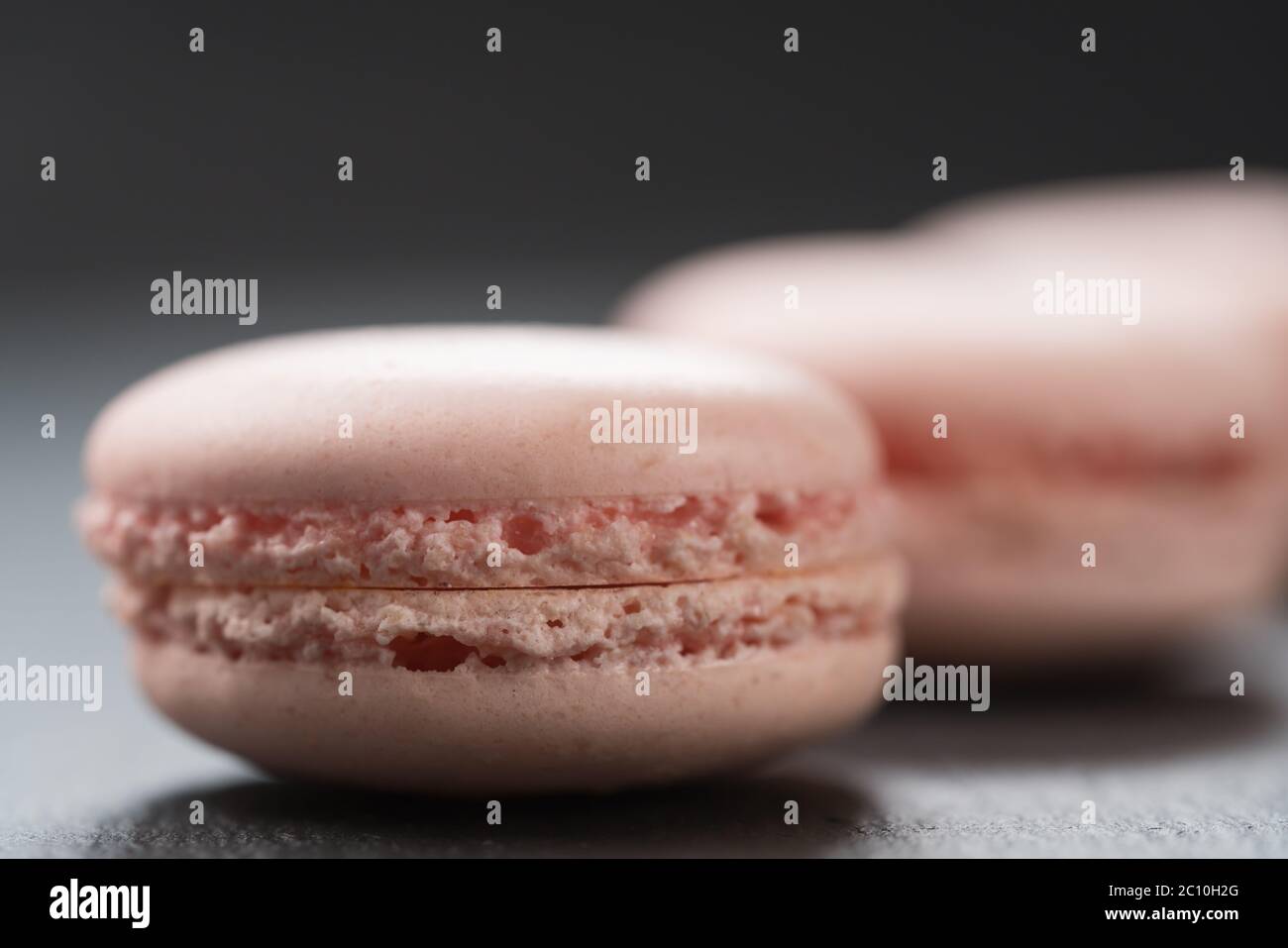Macarons de couleur rose tendre sur fond d'ardoise gros plan Banque D'Images