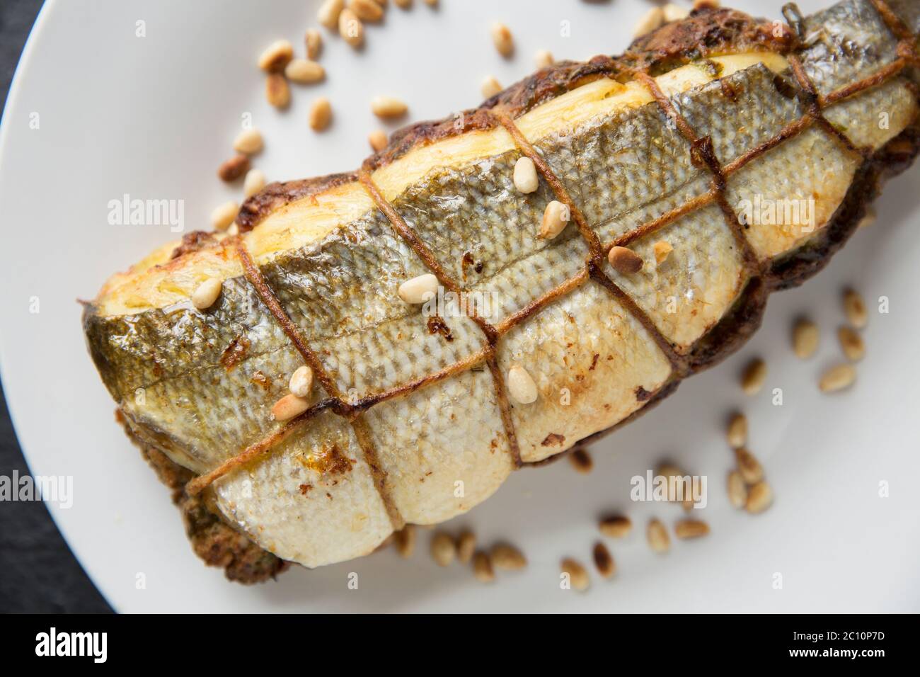 Une basse, Dicentrarchus labrax, qui a été désossée et farcie d'un chapelure, d'un œuf, de persil, de pignons, de zeste de citron, de jus de citron et de beurre fondu Banque D'Images