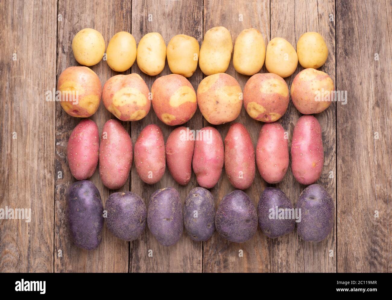 Différents types de pommes de terre sur table rustique en bois Banque D'Images