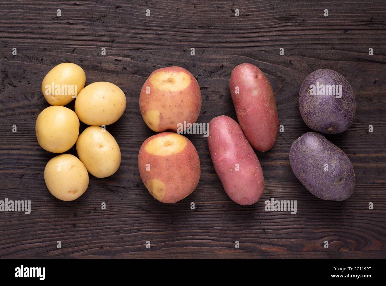 Différents types de pommes de terre sur table rustique en bois sombre Banque D'Images