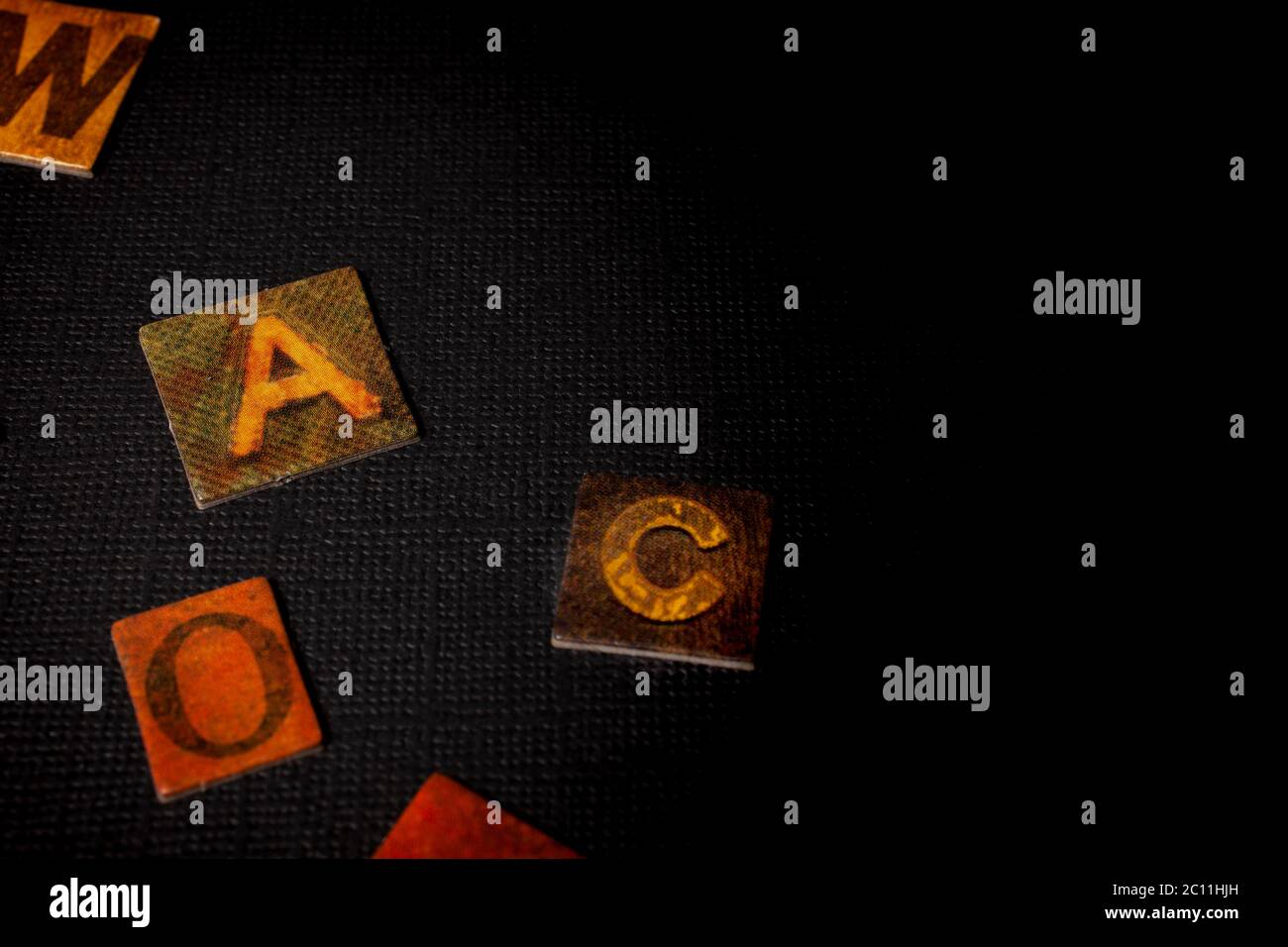 Texte, message, lettres dispersés dans une enveloppe blanche isolée sur fond noir Banque D'Images