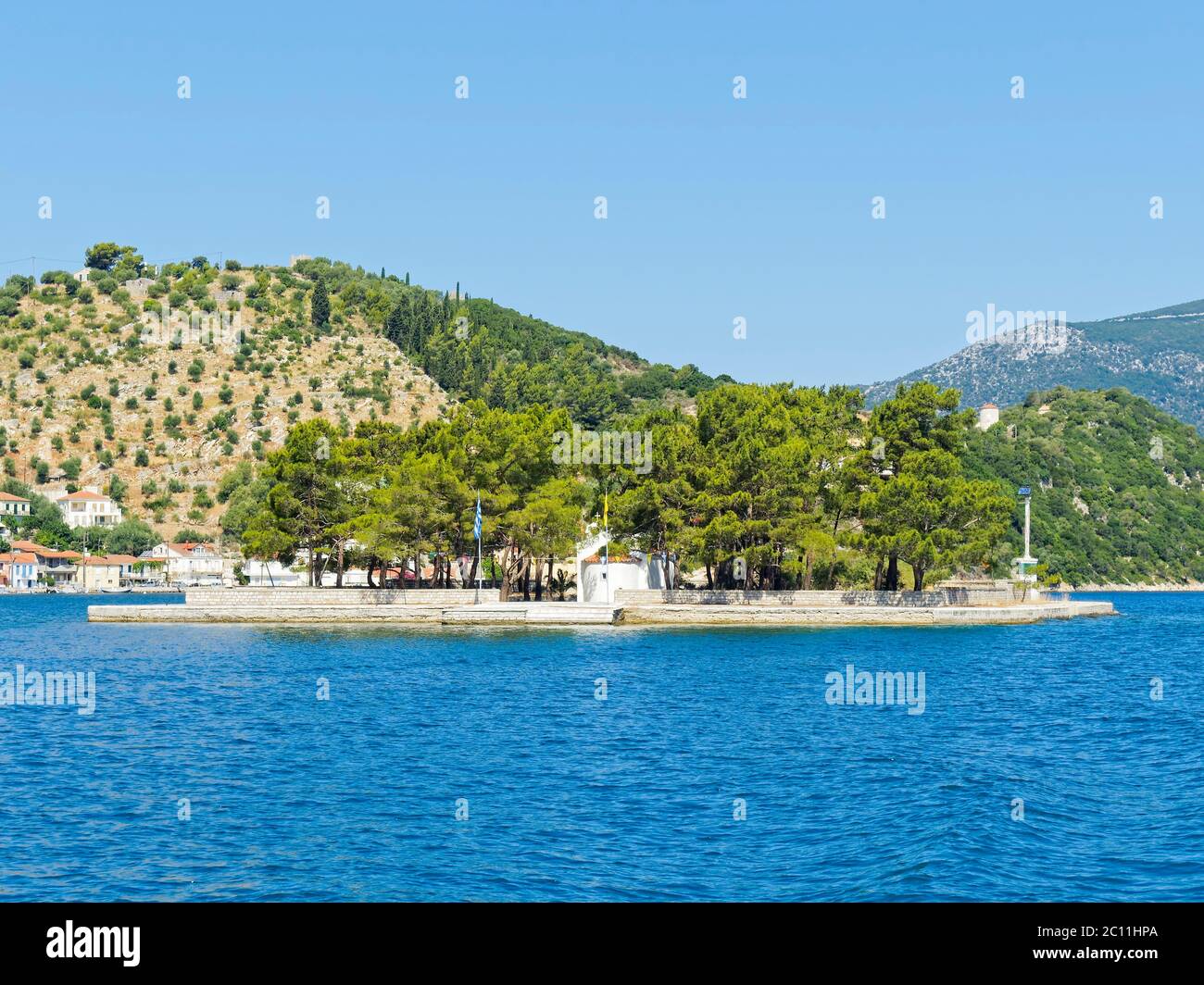 Une petite église blanchie à la chaux se dresse sur l'îlot de Lazareto, près de vithi sur l'île d'Ithaka, entouré d'arbres. Banque D'Images