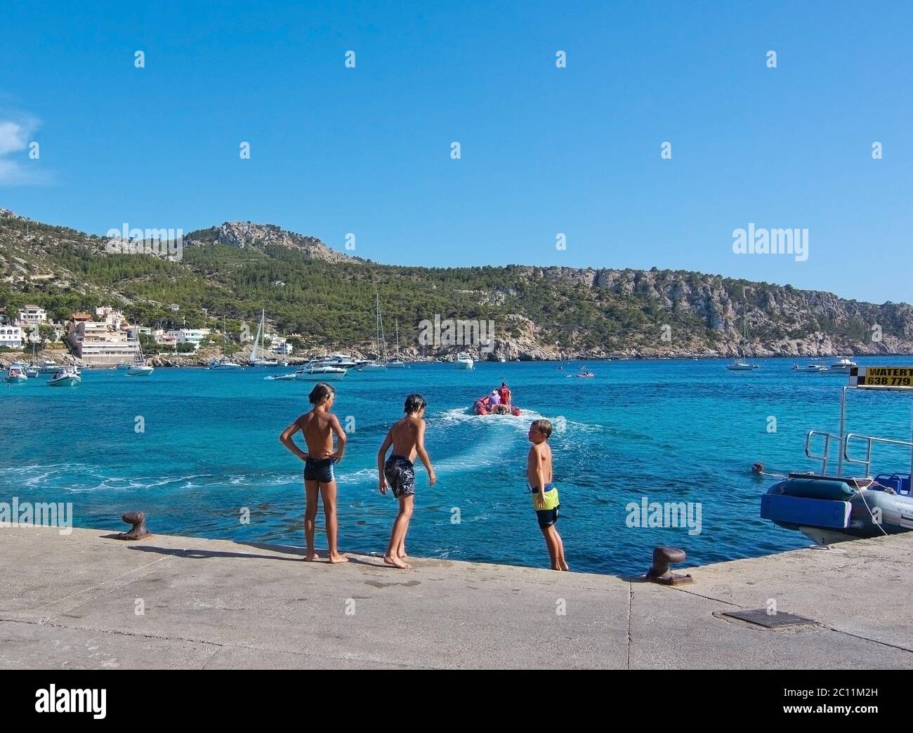 Départ du bateau et enfants sautant du quai Banque D'Images