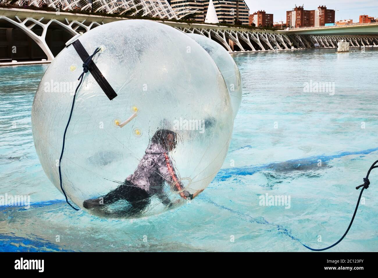 Tourisme s'amuser à l'intérieur d'une grande sphère flottante transparente au parc scientifique, Valence, Espagne. Banque D'Images