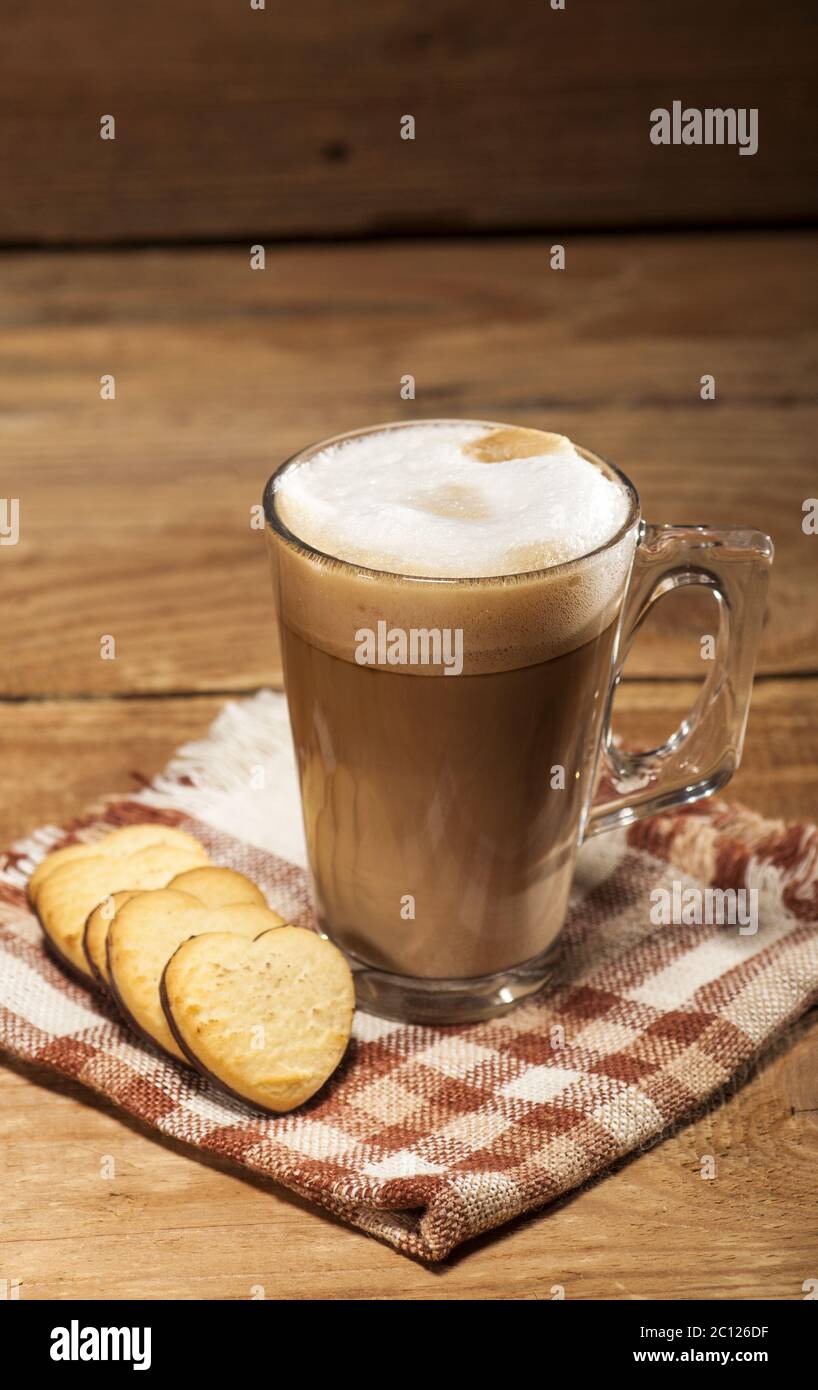 Tasse en verre avec café et biscuits en forme de coeur Banque D'Images