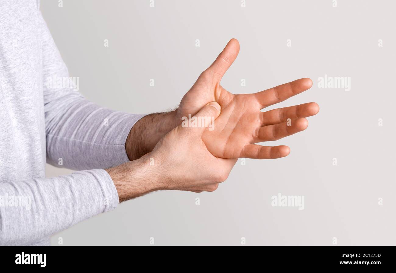 Mal de corps. L'homme appuie sa main à la main dans la douleur due à l'arthrite ou à la blessure Banque D'Images