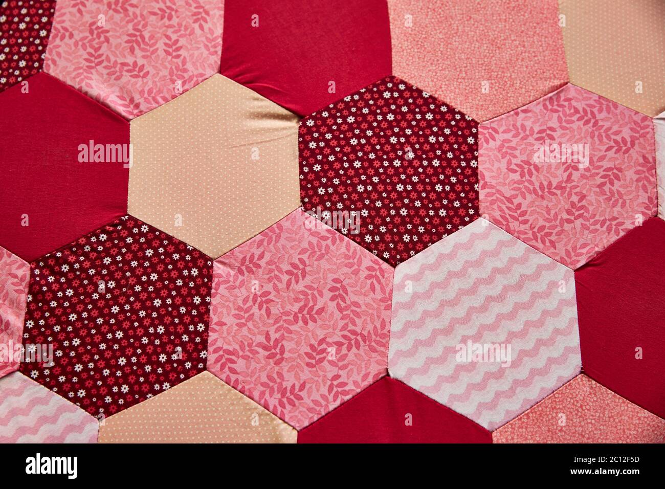 Gros plan sur un motif patchwork en tissu hexagonal traditionnel coloré. Banque D'Images