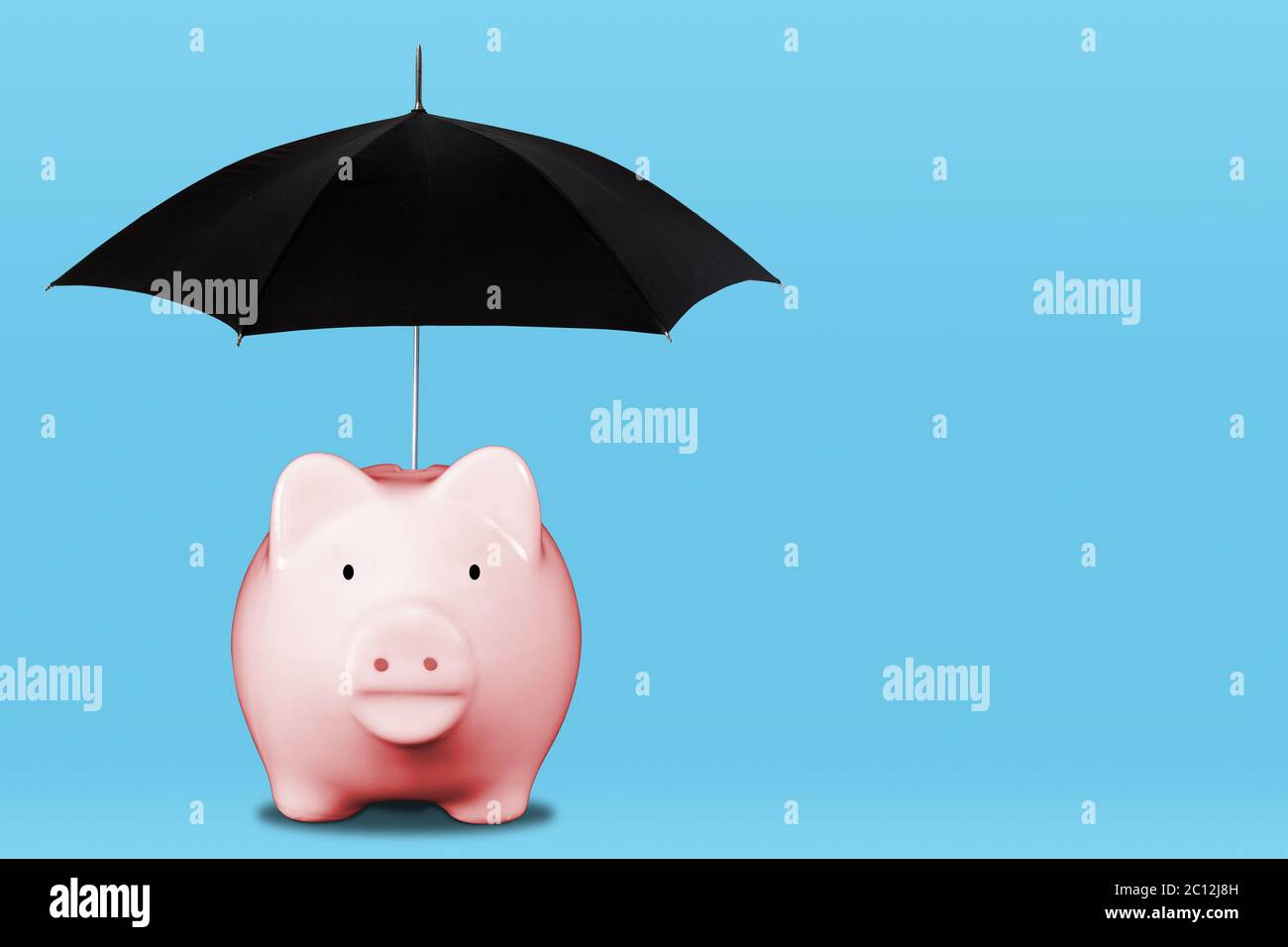 Économisez pour une journée de pluie avec une tirelire rose et un parapluie. Concept de sécurité financière, d'épargne, de couverture d'assurance, de gestion de patrimoine, etc Banque D'Images
