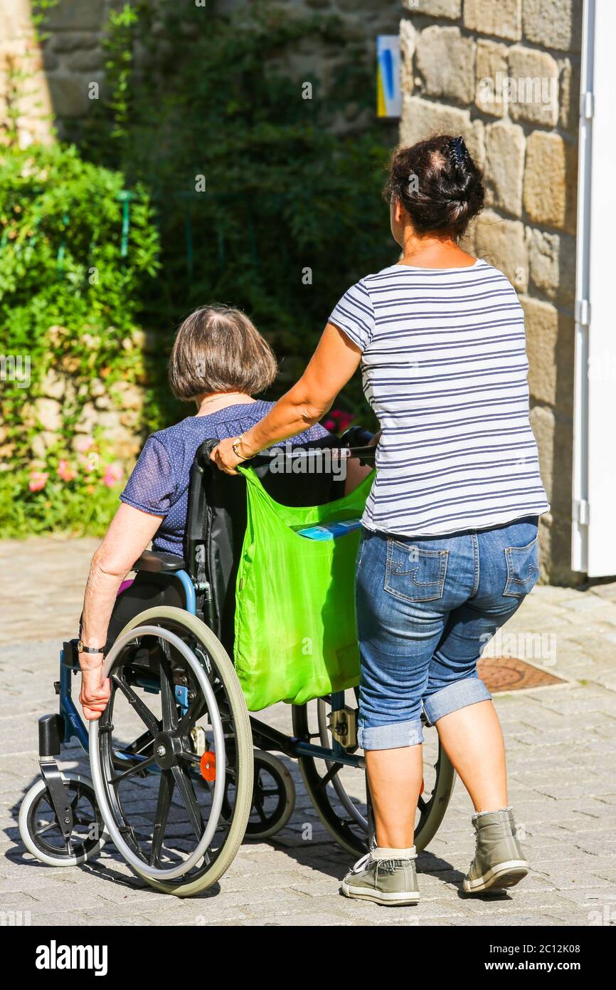 femme aidant une vieille femme en fauteuil roulant Banque D'Images