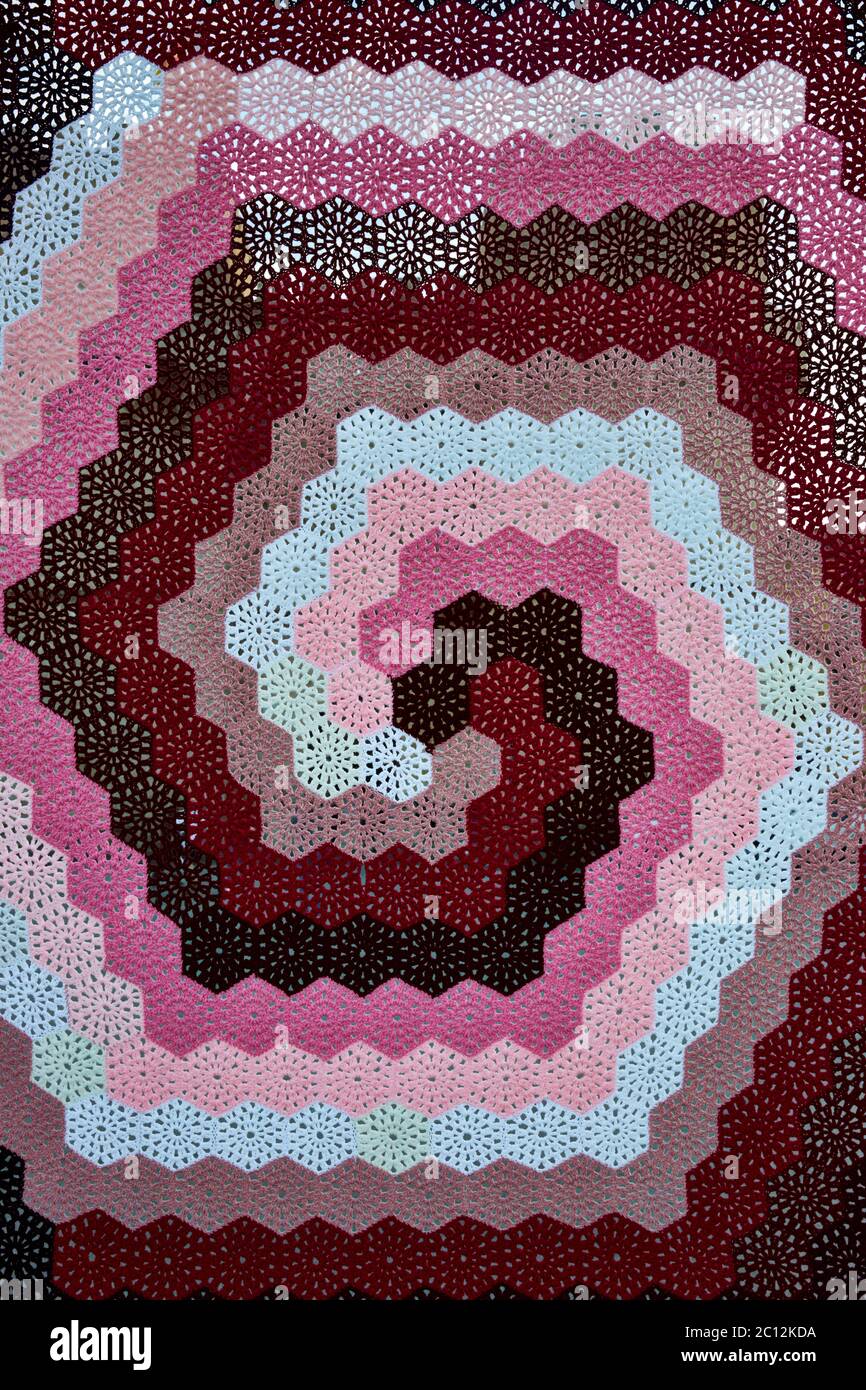 Gros plan sur un motif en crochet hexagonal traditionnel en spirale coloré. Banque D'Images