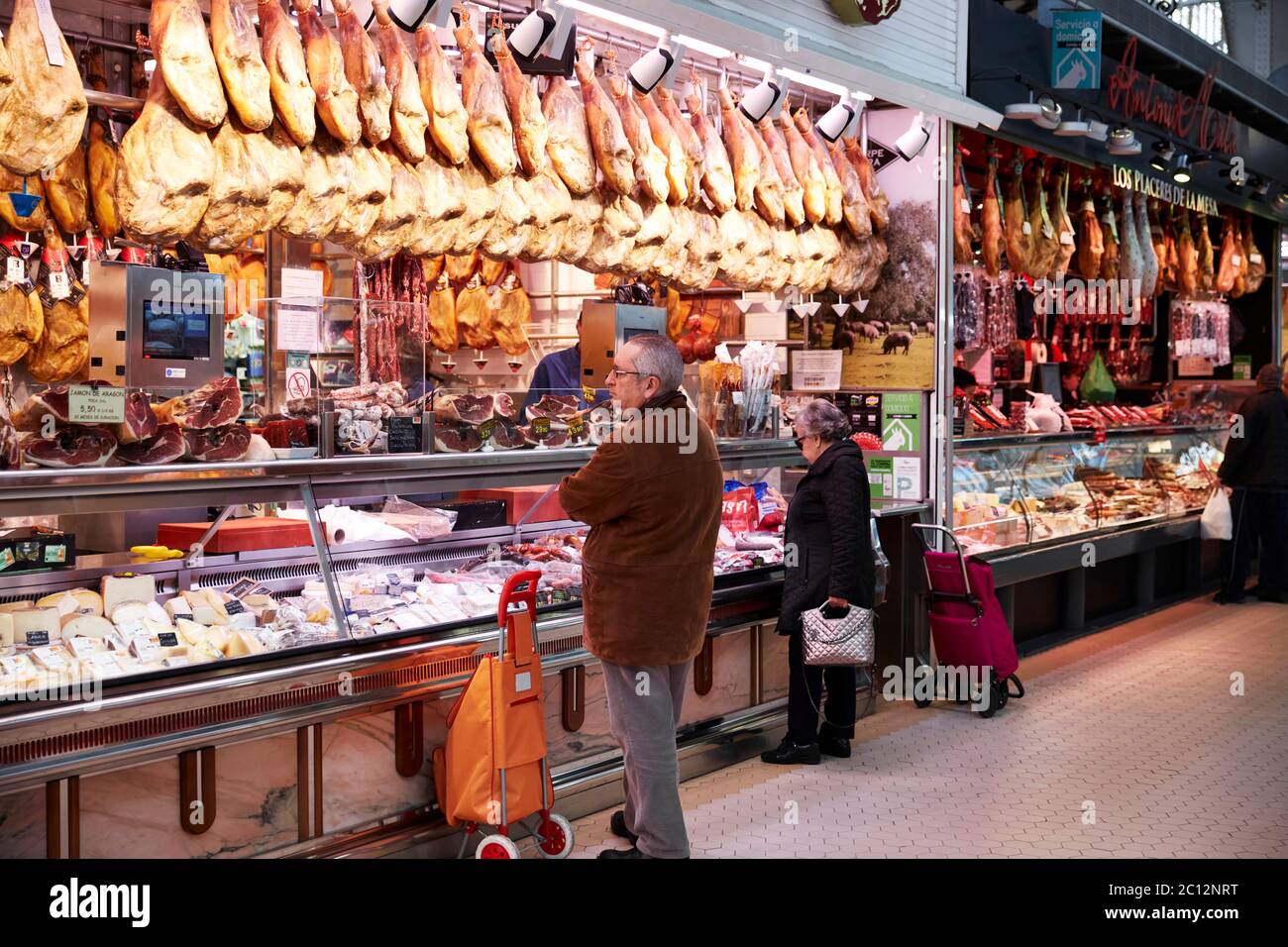 Étals vendant de la viande et des fromages au marché central de Valence, Espagne. Banque D'Images