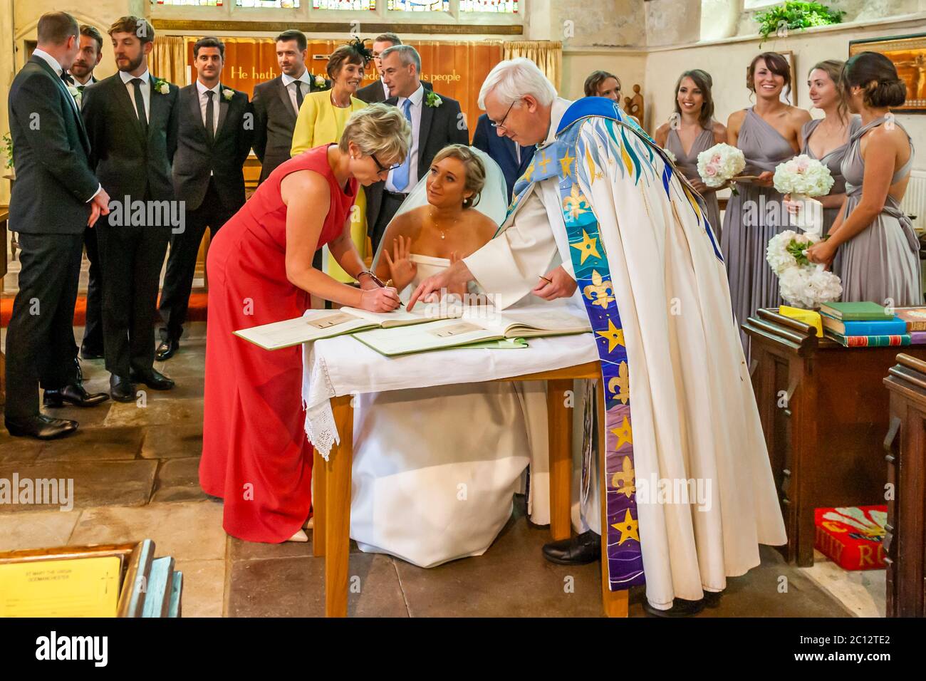 La mariée signe les documents de mariage dans l'Église anglicane. Mariage britannique dans le sud de Cambridgeshire, Angleterre Banque D'Images