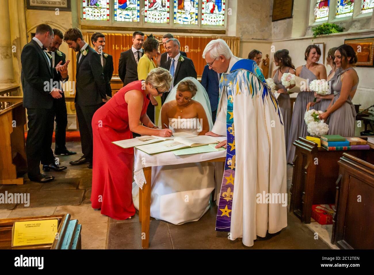 La mariée signe les documents de mariage dans l'Église anglicane. Mariage britannique dans le sud de Cambridgeshire, Angleterre Banque D'Images